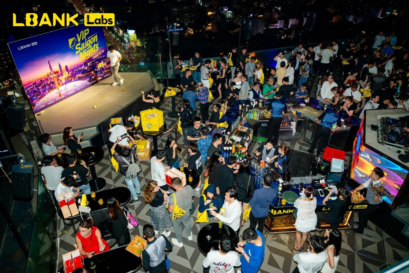 Aerial view of the crowded rooftop at LBank Labs VIP Saigon Nights in Ho Chi Minh City