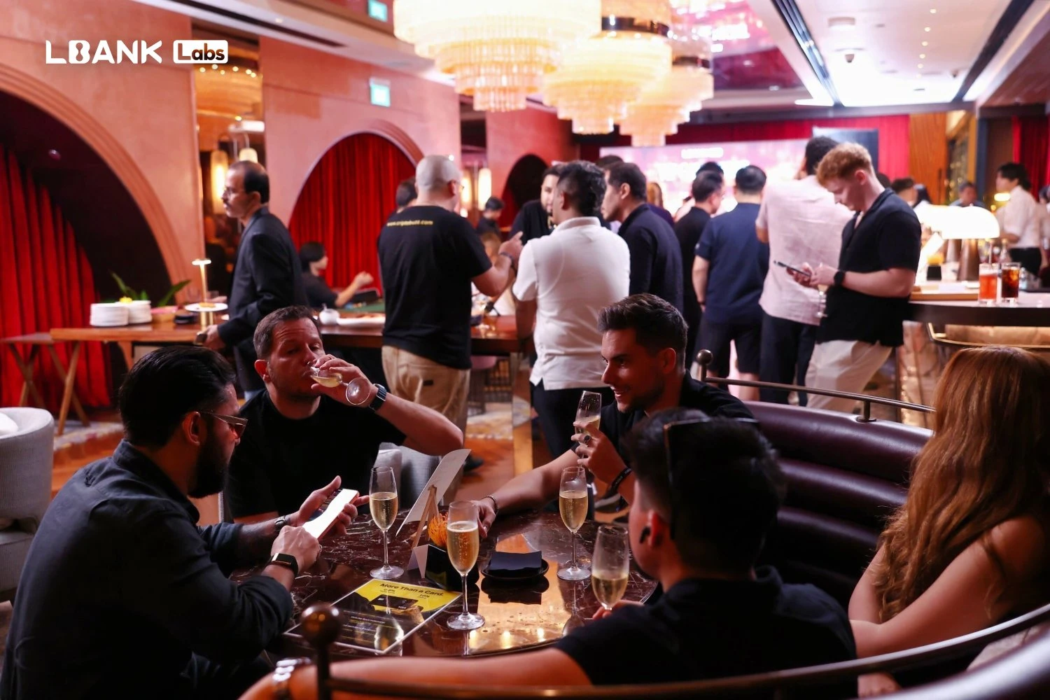 VIP guests sharing champagne at a lounge table during the LBank Labs event in Singapore